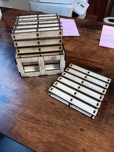 a wooden box sitting on top of a table next to some post it notes and a printer