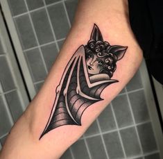 a woman's arm with a bat tattoo on it