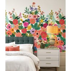 a bedroom with colorful flowers painted on the wall