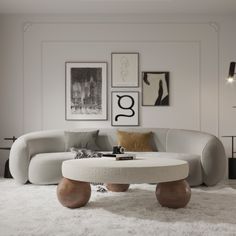 a living room with white furniture and pictures on the wall above it's coffee table