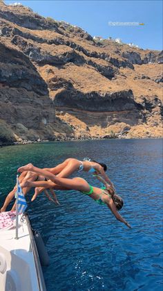 two people diving into the water from a boat