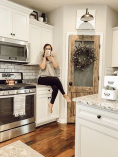 a woman is jumping in the air while drinking from a mug