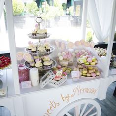 an assortment of cupcakes and pastries displayed on a cart