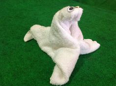 a white stuffed animal laying on top of green carpet