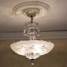 a chandelier hanging from the ceiling in a room with beige walls and ceilings