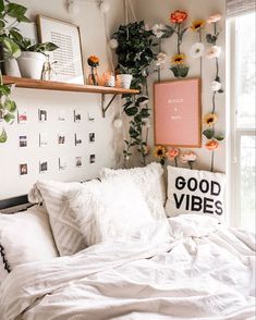 a bed with white linens and flowers on the wall above it is in front of a window