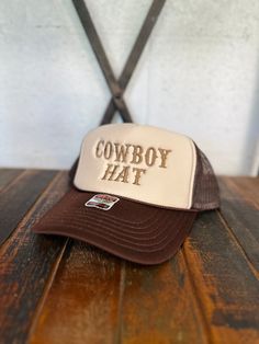 Brown threaded "COWBOY HAT" embroidered on a Brown & Tan Otto brand foam trucker hat. The perfect accessory to make a bold statement! Cheap Brown Trucker Hat With Letter Print, Trucker Hat With Embroidered Patch And Flat Brim, Adjustable Trucker Hat With Embroidered Logo, Trucker Hat With Letter Patch Snapback, Trucker Hat With Letter Patch And Flat Brim, Trucker Cap With Letter Patch, Brown Trucker Hat With Letter Print And Flat Brim, Brown Trucker Hat With Embroidered Patch, Rodeo Trucker Snapback Hat