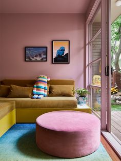 a living room filled with furniture and pink walls