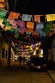 a car parked on the side of a street next to a string of colorful flags