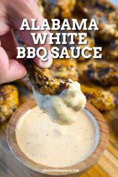 a hand dipping sauce into a small bowl with chicken wings on it and the words, alabama white bbq sauce