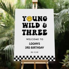 a sign that says young, wild and three with a smiley face on the front