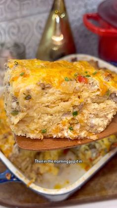 a wooden spoon holding up a casserole dish with meat and cheese on it