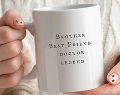 a woman holding a coffee mug with the words brother best friend doctor legend on it