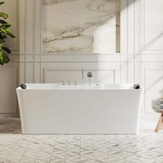 a large white bath tub sitting next to a plant in a room with marble walls