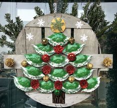 a christmas tree made out of cupcakes sitting on top of a wooden chair