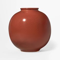 a brown vase sitting on top of a white table