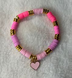 Heishi/clay beaded bracelet: Pink heart heishi/clay beaded bracelet -good quality -very stretchy -one size: about 6.5 inches (can stretch to around 8 inches) This bracelet includes various shades of pink heishi/clay beads, gold spacers, and a light pink heart charm upon very stretchy string.  Sizing: This bracelet comes in one size (measures about 6.5 inches) and is meant to fit people with small and medium size wrists. If you have a larger wrist than about 8 inches, then send me a message to ge Clay Bead Bracelet Ideas Hot Pink, Pink Clay Bead Phone Charm, Clay Bead Bracelet Pink, Trendy Pink Heishi Beads Stretch Bracelet, Pink Heishi Beads Stretch Bracelet For Friendship, Bracelets Preppy, Clay Beaded Bracelet, Light Pink Heart, Fit People