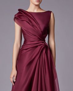 a woman is wearing a dress with a draped over it