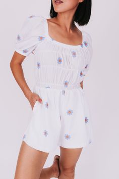 Flower power! Get ready for a beautiful day in this romper adorned with embroidered flowers. The square neckline and puffy sleeves add a flirty touch while pockets provide practicality. Perfect for any adventure (or just lounging around). Happy vibes included! Details Embroidered flowers Square neckline Puffy sleeves Pockets Sizing Approximate measurements: SIZE LENGTH/INSEAM BUST Small 28/2" 30" Medium 29/2" 32" Large 30/2" 34" Fabric has stretchModel is 5’7 wearing small Material 100% CottonHa Spring Square Neck Jumpsuits And Rompers, Spring Cotton Jumpsuits And Rompers With Smocked Bodice, Spring Cotton Jumpsuit With Smocked Bodice, Summer Jumpsuits And Rompers With Square Neck, Spring Jumpsuits And Rompers With Smocked Back, Spring Relaxed Fit Jumpsuit With Smocked Back, Stock Flower, Happy Vibes, The Square