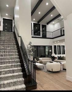 a living room filled with furniture and stairs