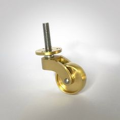 a gold plated metal object with a screw in it's center on a white background