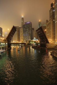 the city is lit up at night and it looks like they are going under an arch