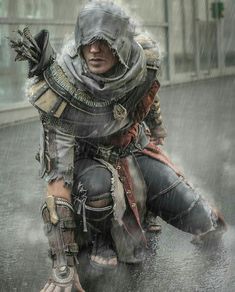 a man dressed in armor crouching down on the ground with an umbrella over his head