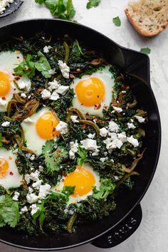 an iron skillet filled with eggs and greens