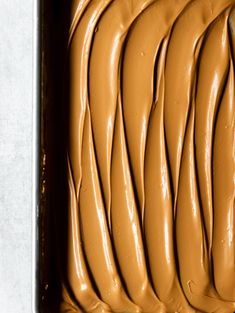 a pan filled with chocolate frosting on top of a counter