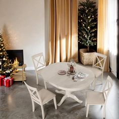 a white table and chairs in front of a christmas tree