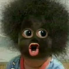 a black person with an afro is making a funny face