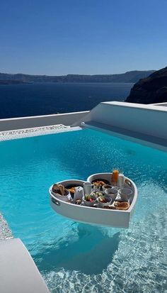 a heart shaped table is in the middle of an empty pool with food on it