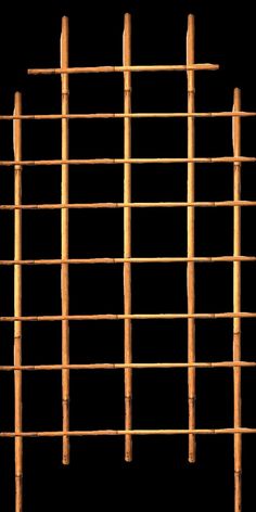 a close up of a bamboo fence against a black background