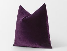 a purple pillow sitting on top of a white table