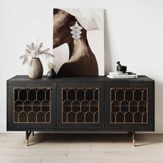 a black and gold sideboard with two vases sitting on it's sides