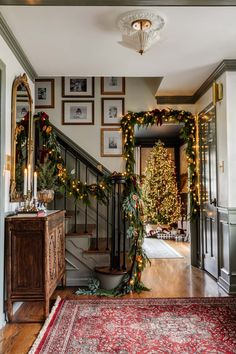 a staircase decorated for christmas with garland and lights