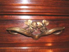 a close up of a wooden drawer with flowers on the top and bottom part of it