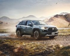 a gray toyota rav driving down a dirt road