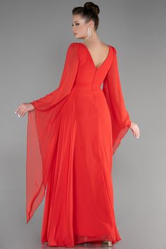 a woman in an orange dress is standing with her hands on her hips and looking back