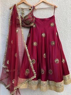 This glamorous crimson lehenga is hand embellished on lush satin with mirror work, cutdaana and swarovski stone details with borders at the hem.  It is teamed with a katori cut blouse and a tulle dupatta with border and buti details. Bhumika Sharma, Pearls Embroidery, Cultural Clothes, Orang India, Desi Vibes, Ethnic Wears, Blouse Works, Mirror Work Lehenga, Wedding Wardrobe