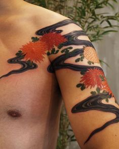 a man's arm with tattoos on it and some plants in the back ground