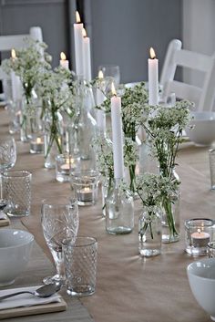 a long table is set with white flowers and candles