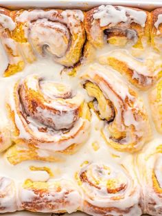 a pan filled with cinnamon rolls covered in icing