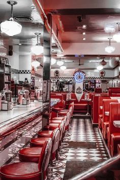 the interior of a diner with red booths and checkered flooring on the walls