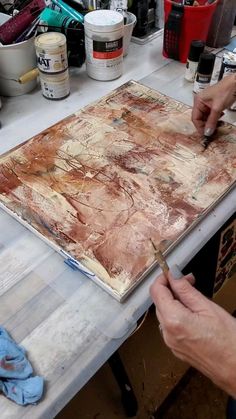 a person is painting on a piece of wood