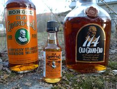 three bottles of old grandad sit on the ground