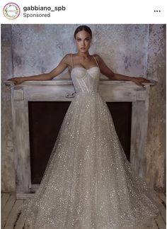 a woman standing in front of a fire place wearing a dress with sequins