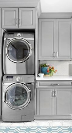 a laundry room with washers and dryers stacked on top of eachother