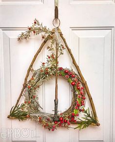 a wreath hanging on the front door of a house decorated with branches, berries and twigs