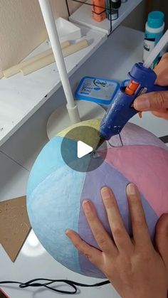 someone is using scissors to cut out the top of a paper ornament with glue